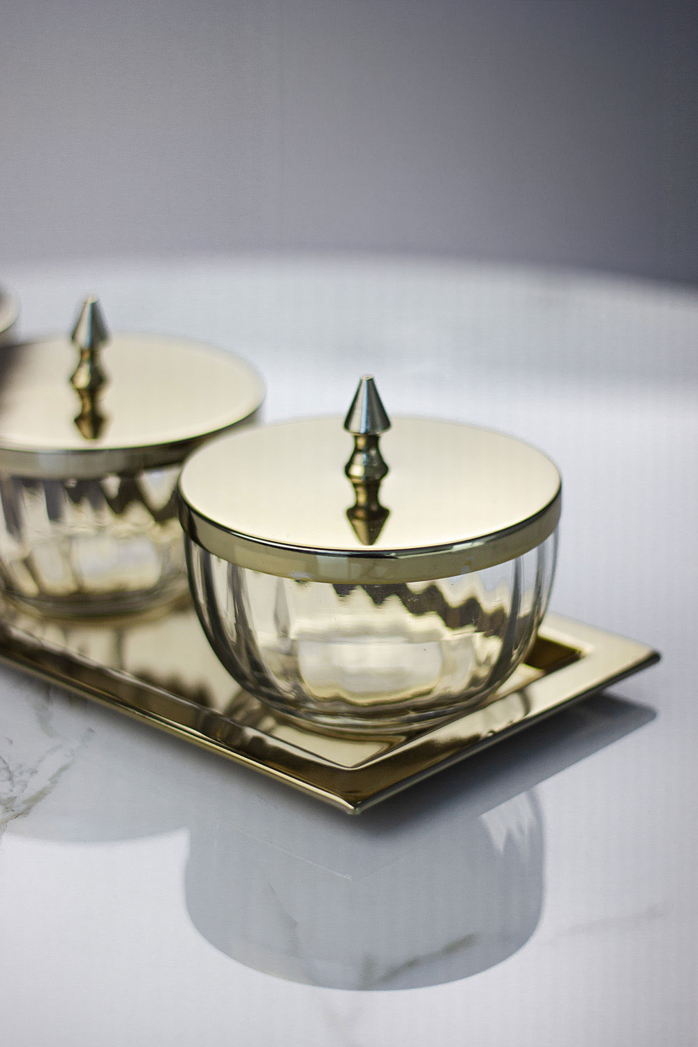 zestaw-czterech-pojemnikow-na-prostokatnej-zlotej-tacy-zlote-metalowe-pokrywki-z-uchwytami-szklane-pojemniki-klasyczny-styl- zestaw-czterech-pojemnikow-na-prostokatnej-zlotej-tacy-zlote-metalowe-pokrywki-z-uchwytami-szklane-pojemniki-klasyczny-styl